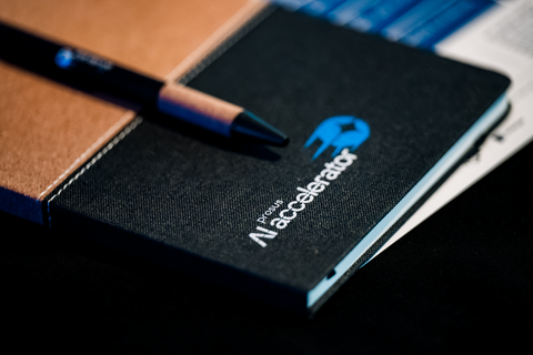 A Prosus AI Accelerator notebook and pen